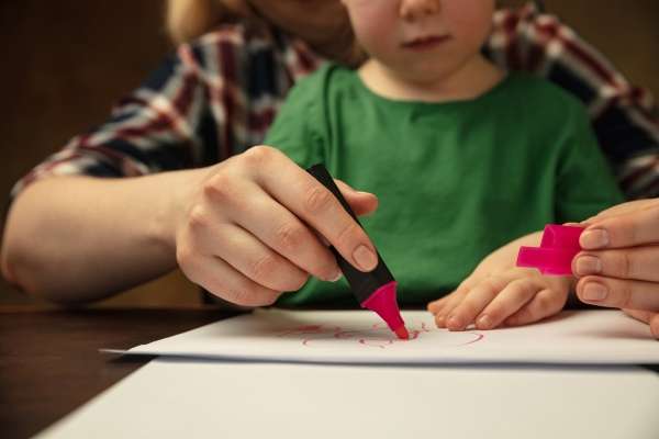 A mother helping her child with letter formation.