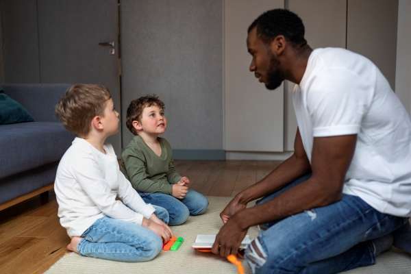 A father engaged in a discussion with his kids.