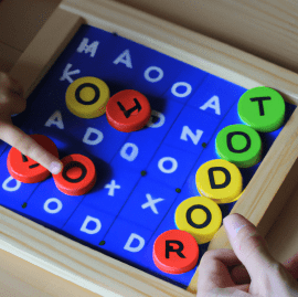 Parent and child engaging in a syllable board game at home.