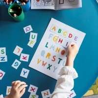 A child engaged in decoding words by sounding out magnetic letters, demonstrating a playful yet educational method