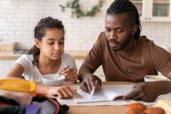 Parent teaching child syllables with books