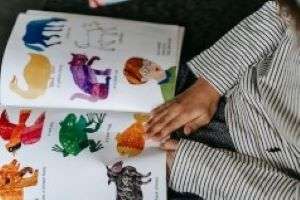 A child using a picture book to decode words