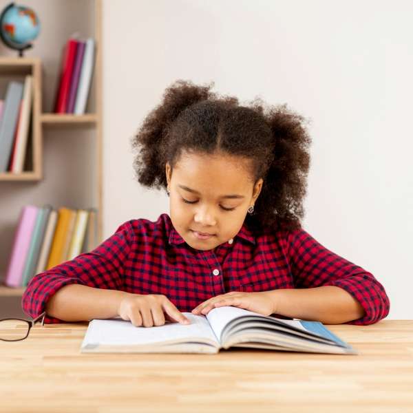 Child finger tracing words in a book 