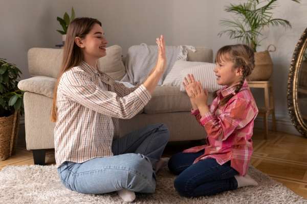 Parent and child clapping to the rhythm of syllables.