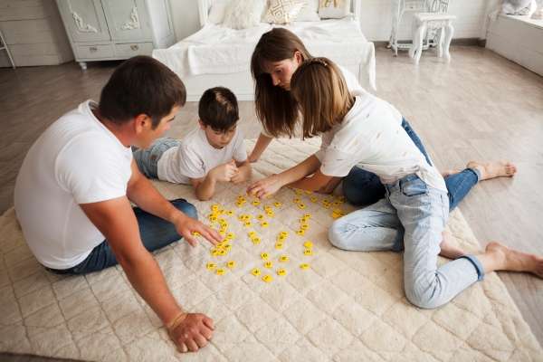 A joyful family engaged in playing Scrabble, making the practice of decoding words interactive and enjoyable.