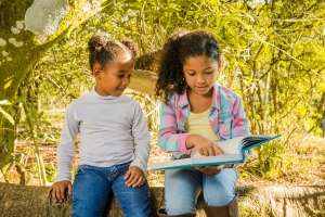 Excited-children-reading word families-under-tree