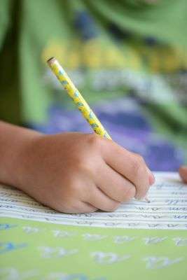 Close-up of a child's hand holding a pencil correctly.