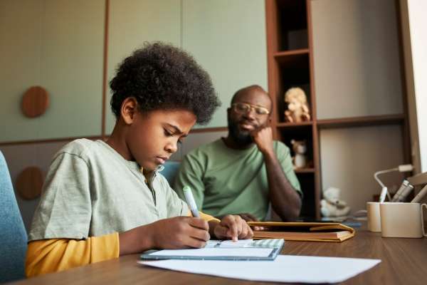 Child summarizing a book in a notebook as a reading strategy.