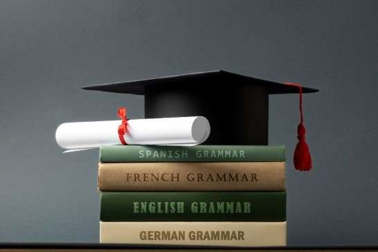 An image of books with a diploma in different languages.