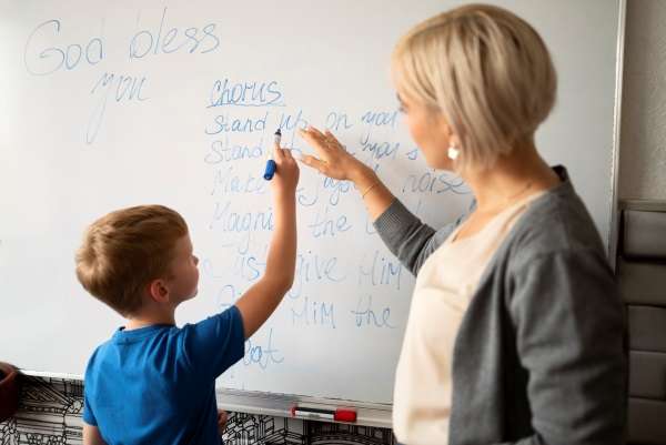 Teacher helping a child with writing.