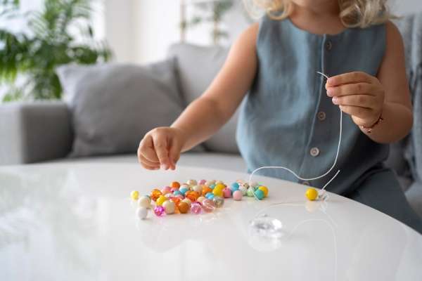 Beads arranged in a pattern on a string by a child. Introducing numeracy concept using patterns