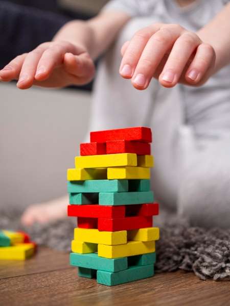 Child learning Patterns and Sequences  through building colorful block tower.