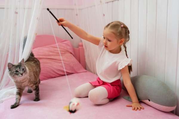 A child playing her pet cat