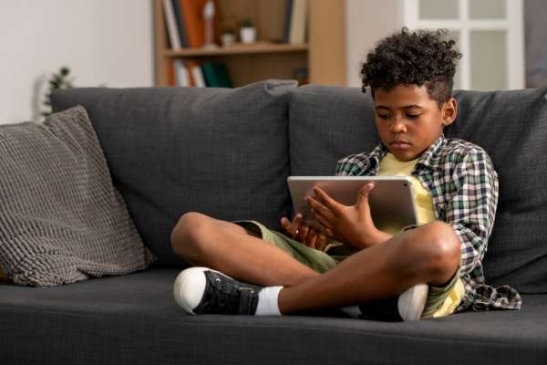 Child seated with a tablet.