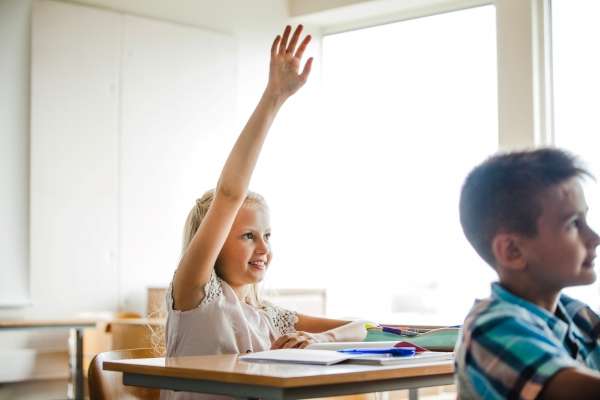 A child raising hand to ask a question to understand numeracy.