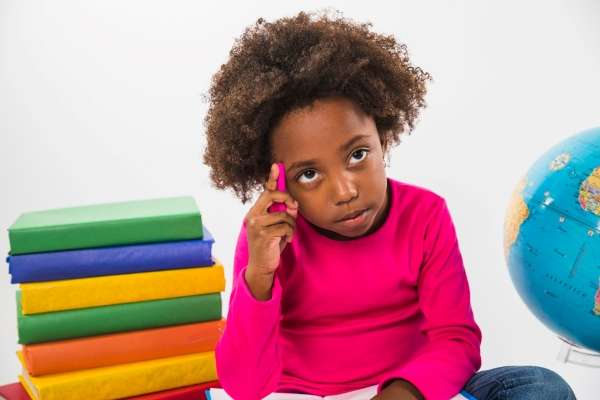 Engrossed child reading a book and thinking predicting about her characters in the book