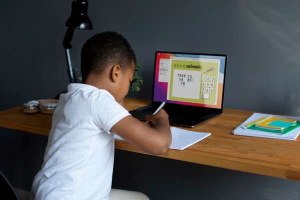 A child interacting with an educational app on a laptop and learning numeracy.