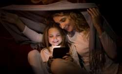 Parent and child reading together in a blanket fort. Reading strategies are fun!