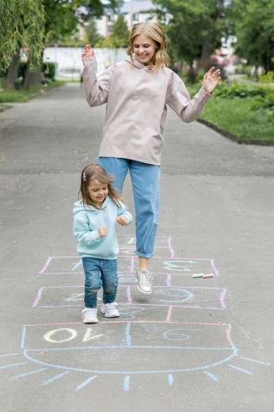 parent and child playing a counting game outdoors.