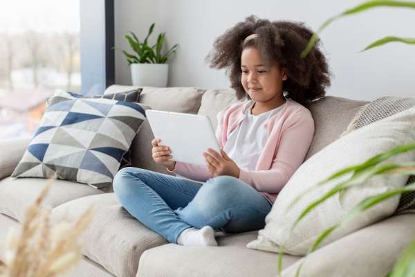 Child examining a reading tool on a tablet to practice reading