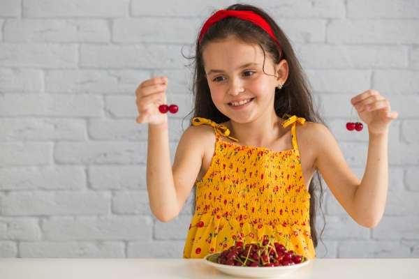 Child using cherries to understand basic  number operations.