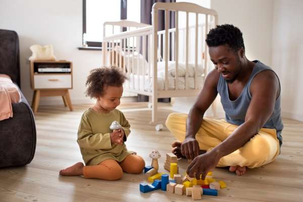 Parent helping a child understand basic number operations through sorting out toys.