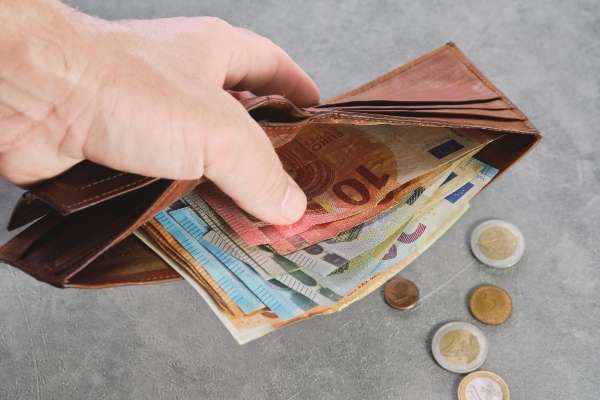 A wallet with notes and coins.