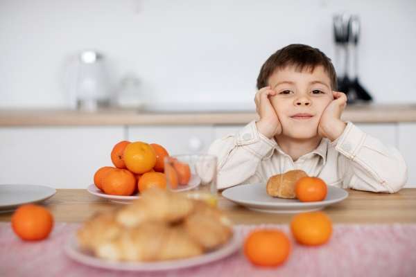 Child counting numbered apples on a table to learn Cardinal Numbers.