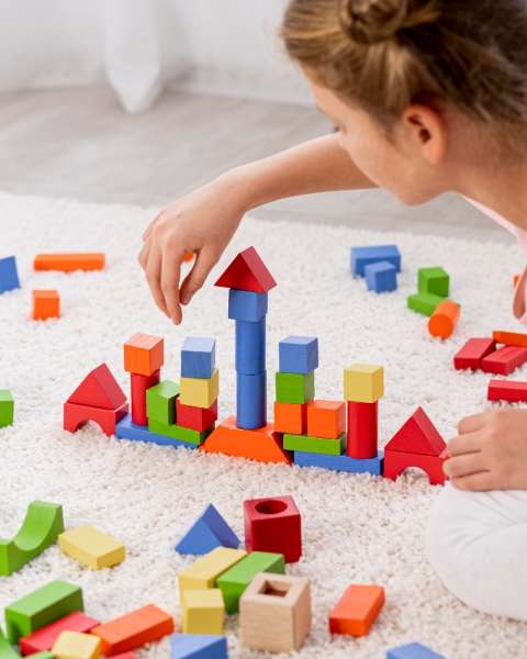 Child building with geometric blocks.