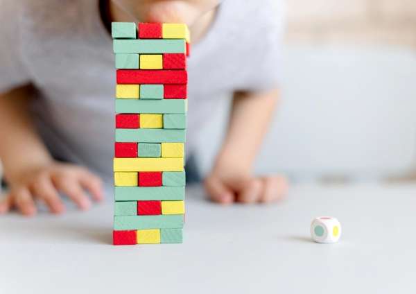 Child hands placing colorful blocks in a sequential pattern to learn basic algebra concepts.