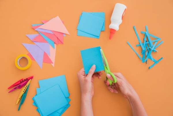 A child using craft, cutting papers into different shapes.