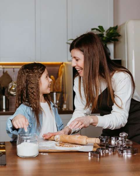 Child and parent baking and measuring ingredients as they learn and understand number words and numeracy.