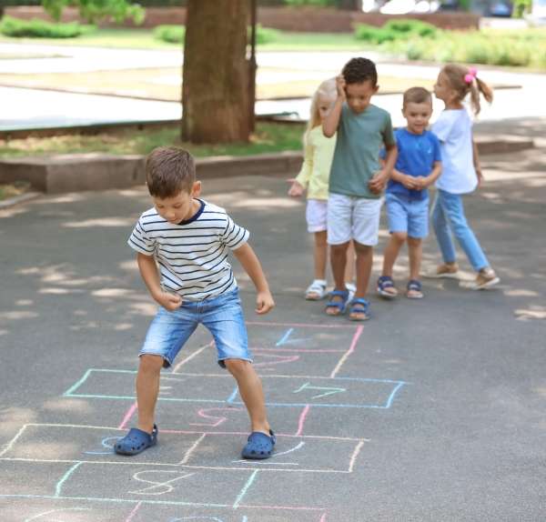 A group of children learning numbers through a hopscotch game.