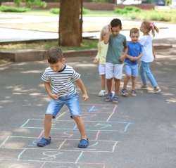 Preschoolers playing hopscotch, to learn cardinal numbers.