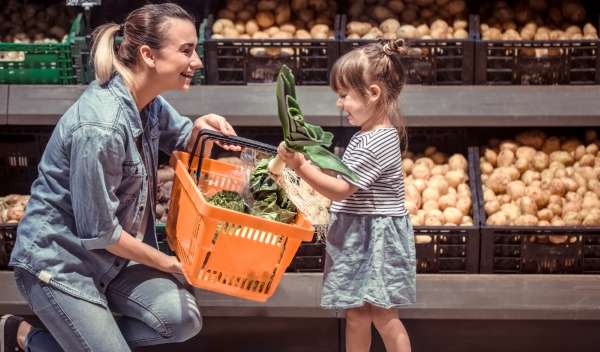 Child sorting groceries in a cart.