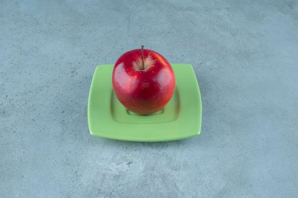 Matching one apple on each plate at the table to teach one-on-one correspondence. 