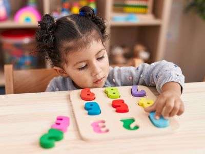 A Child learning basic numeracy problem-solving using number blocks.