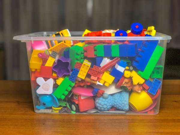 A bucked filled with building blocks and toys for children.